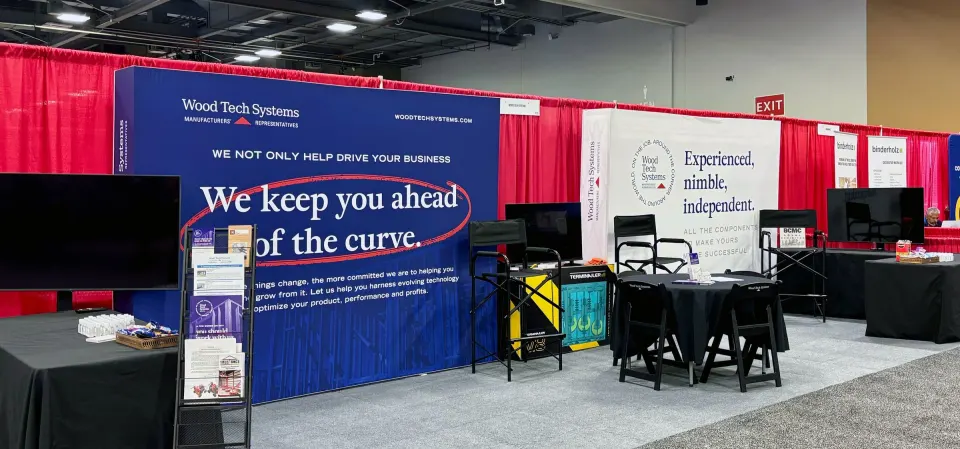 The Wood Tech Systems BCMC trade show booth: a navy panel reading ‘We keep you ahead of the curve’ next to a white panel reading ‘Experienced, nimble, independent.’